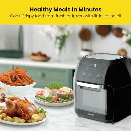 Air fryer on kitchen counter with cooked chicken, sweet potato fries, and vegetables.