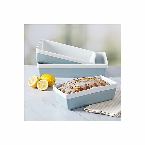 Stacked ceramic loaf pans with a lemon bread and lemons