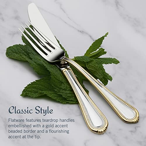 Fork and knife with gold accents on mint leaves, marble background.