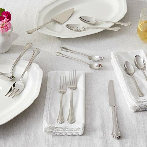 Elegant silverware arranged on a dining table with white napkins and plates