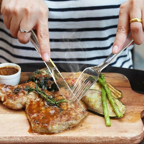 Person cutting grilled steak with vegetables on wooden board.