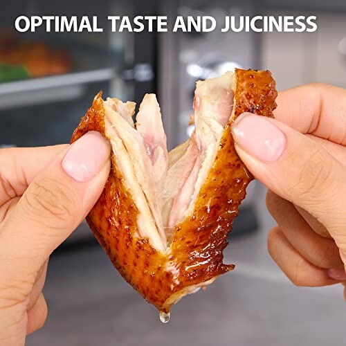 Hands pulling apart a piece of juicy cooked chicken