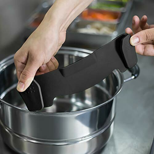 Person holding a black silicone grip over a stainless steel pot