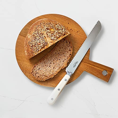 Sliced bread on a wooden cutting board with a serrated knife.